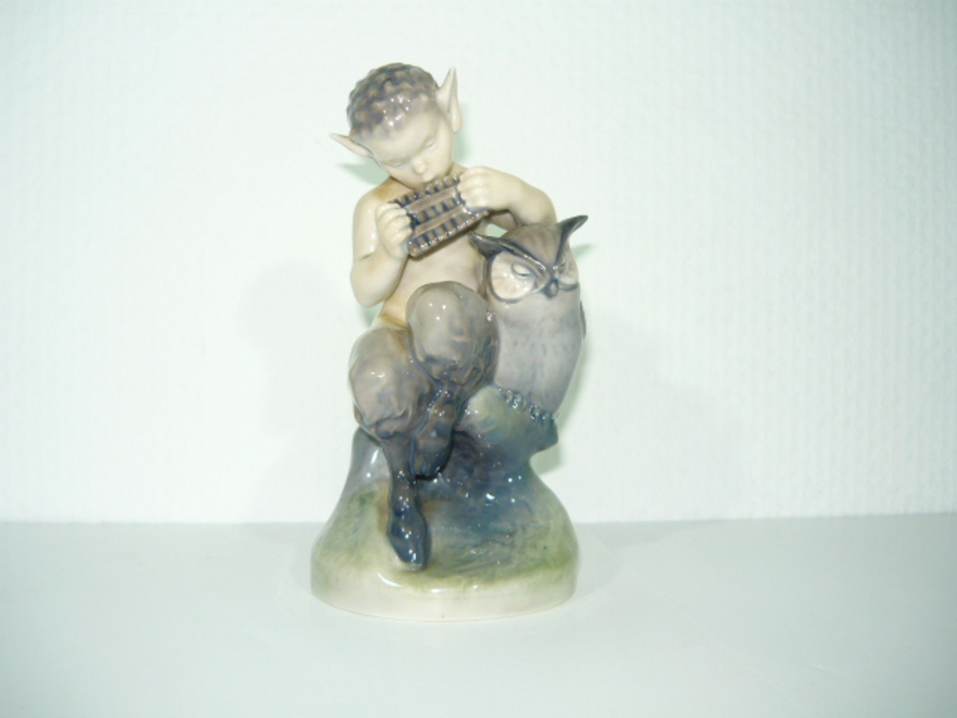 Royal Copenhagen. Faun mit Eule und Panflöte. Entw. Christian Thomsen. I.W. h. 16cm. KOSTENLOSER