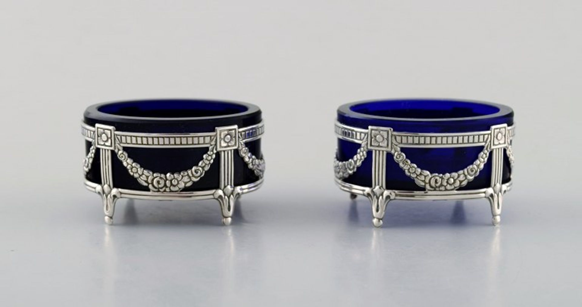 Schwedischer Silberschmied. Zwei Salzgefäße im Empire-Stil mit königsblauem Glaseinsatz. Je ca. 6cm.