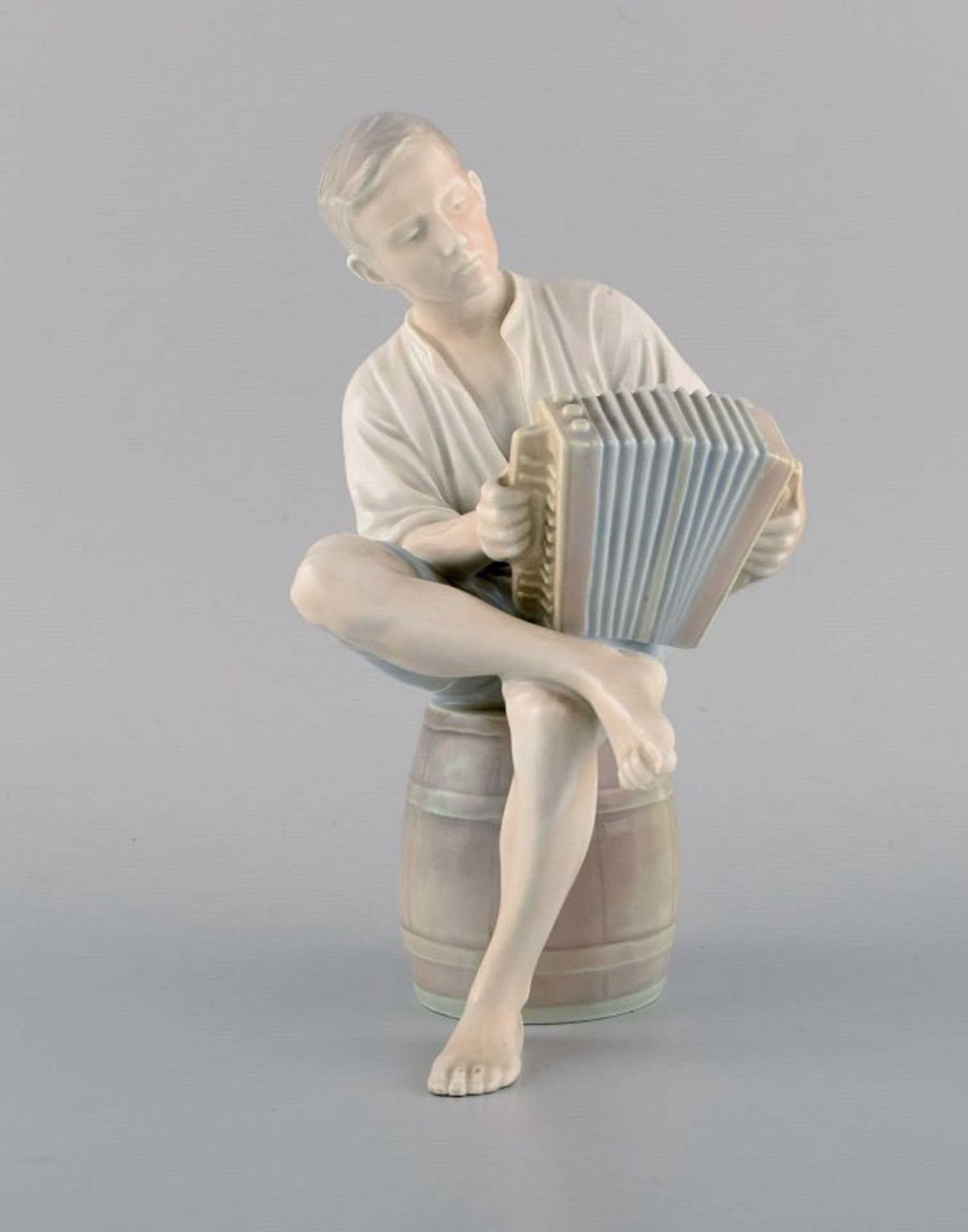 Bing & GrøndahlPorzellanfigur. Junge mit Akkordeon. 1950er. Modell: 1661. I.W. H. 22cm.