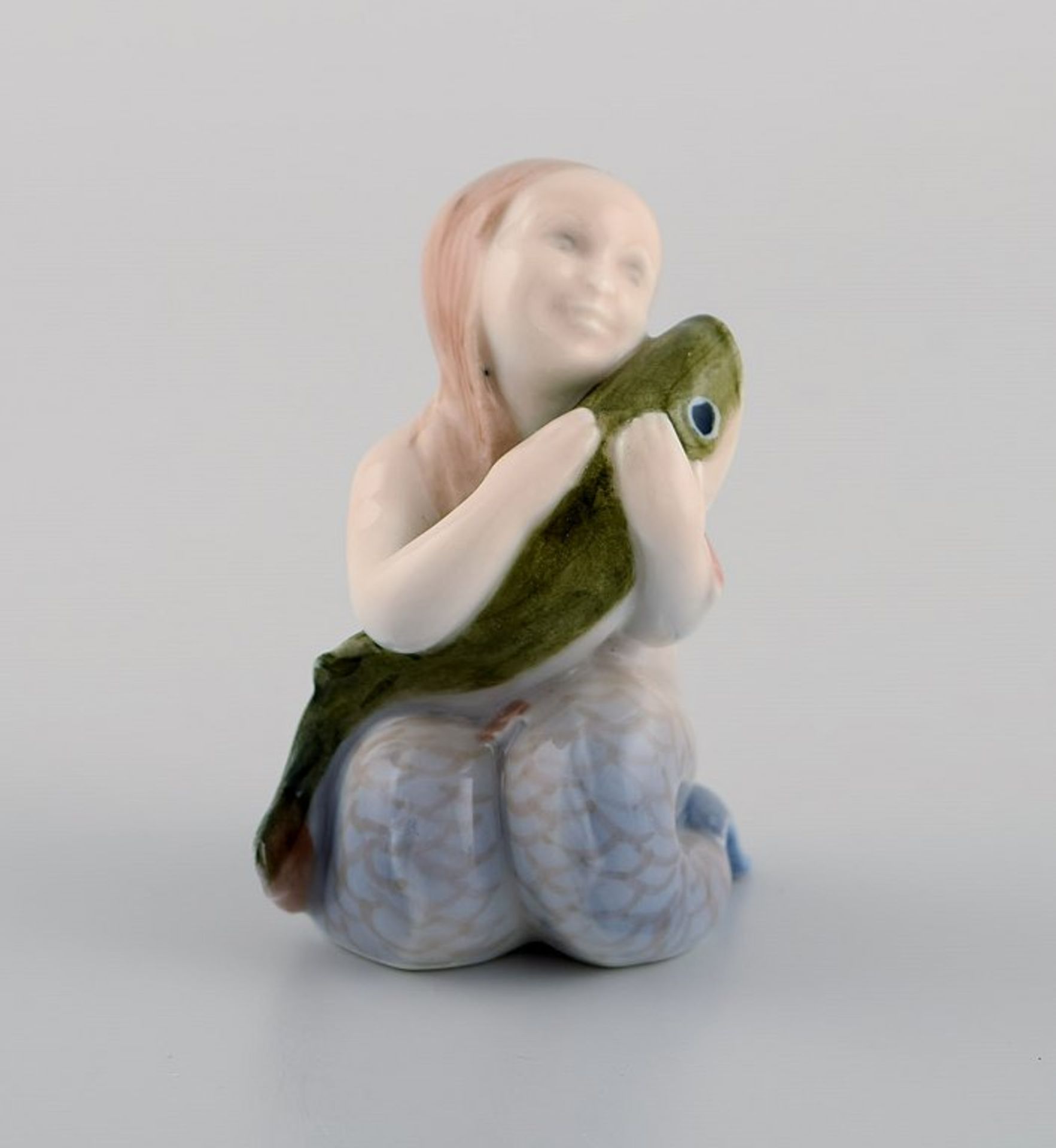 Royal Copenhagen Porzellanfigur. Meerjungfrau mit Fisch. Um 1920. Modell 2348. I.W. h. ca. 7cm