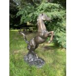 Modern bronze cast metal garden study of a rearing horse.