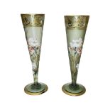 A pair of green and gilded glass vases, hand painted with flowers by Mont Joye Glass.