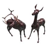 A patinated cast metal sculpture of a standing stag