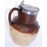 A salt glaze harvest jug with silver mounts and lid.