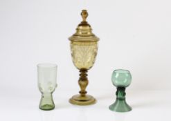 Deckelpokal und zwei Weinpokale Um 1900. Honigfarbenes Glas. Godronierter Nodus, Pokal mit Sc