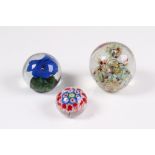 Konvolut. Drei Paperweight. Dekore. Millefiori, blaue Blume und Einschmelzungen in Türkis u