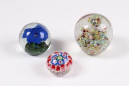 Konvolut. Drei Paperweight. Dekore. Millefiori, blaue Blume und Einschmelzungen in Türkis u