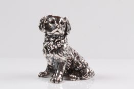 Hundefigur. 20. Jh. Sterlingüberzug, gefüllt. Sitzender Spaniel. Gew. 478 g. H: 13,5 cm.