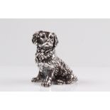 Hundefigur. 20. Jh. Sterlingüberzug, gefüllt. Sitzender Spaniel. Gew. 478 g. H: 13,5 cm.