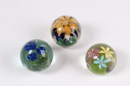 Konvolut. Drei Paperweight. Farbloses Glas, farbige Einschmelzungen verschiedener Blüten. H: