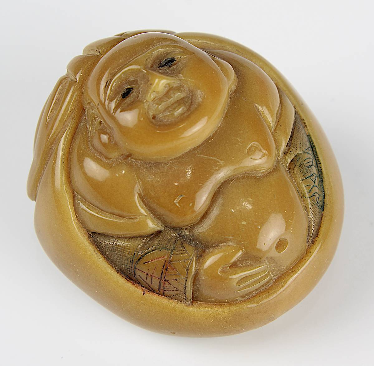 Japanisches Netsuke aus Taguanuss, 19. Jh., fein geschnitzter Buddha, seitlich mit geritzter