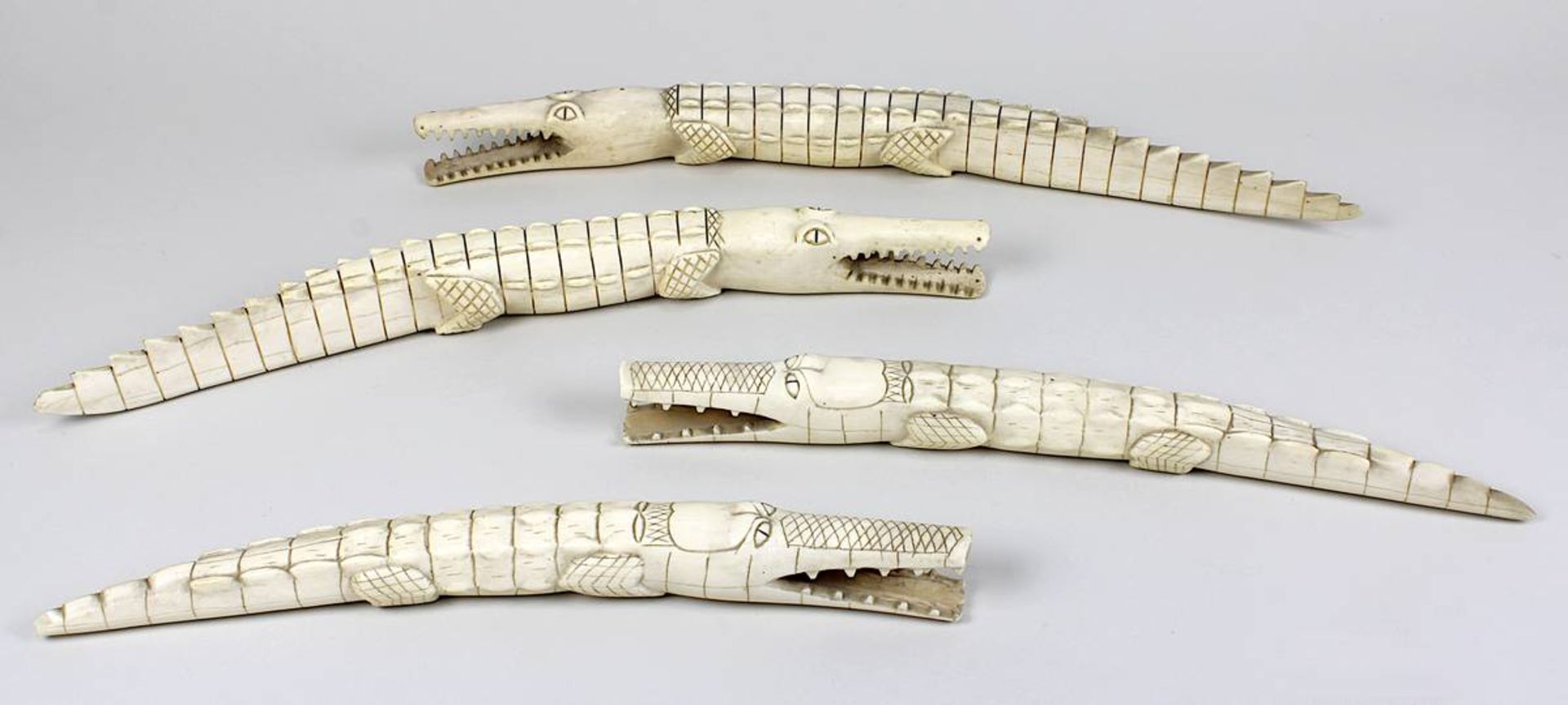 4 Elfenbein-Krokodile, um 1940, jew. aus einem Stück geschnitzt, alle etwas unterschiedlich