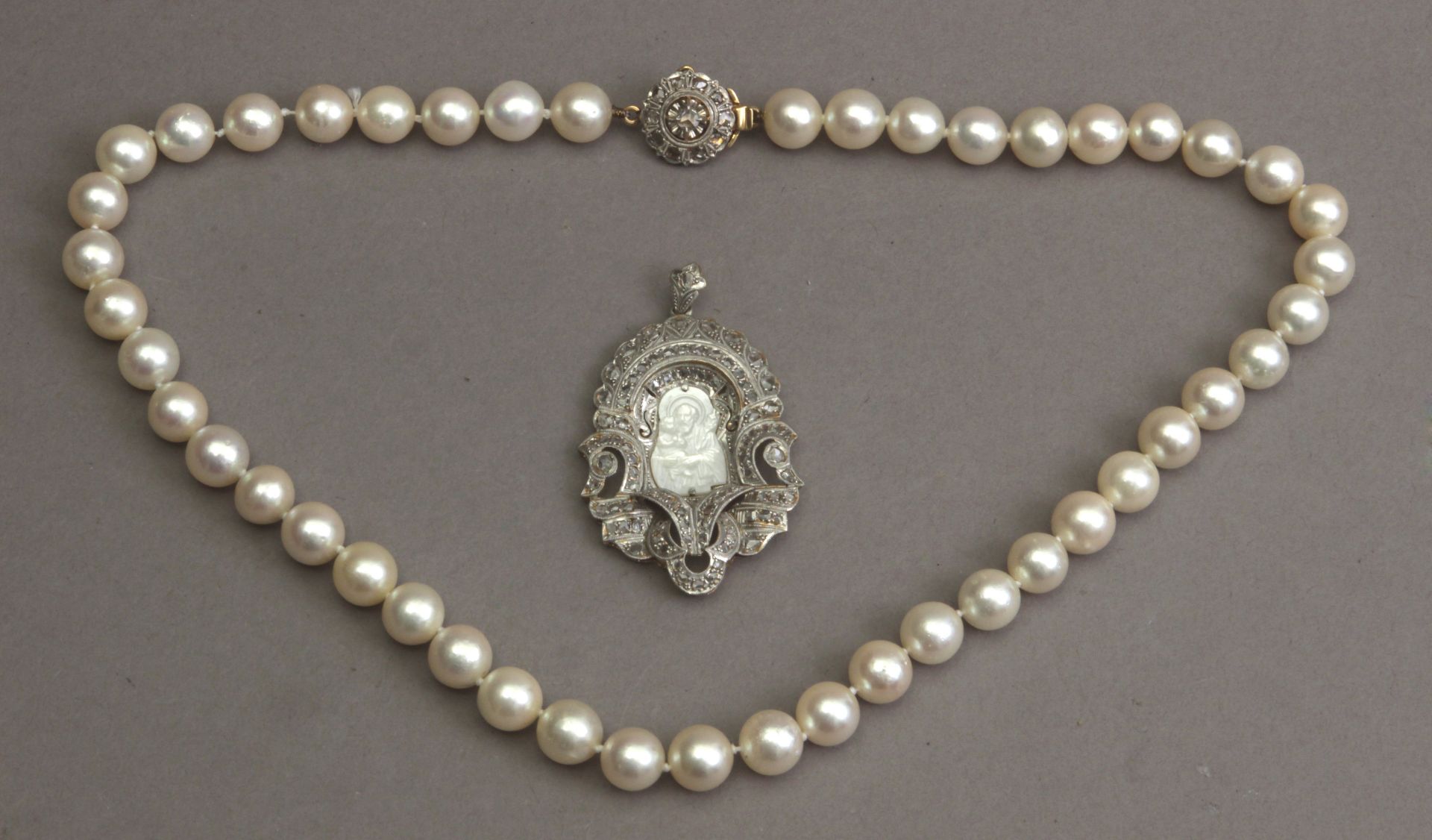 An Art-Déco devotional medal and a cultured pearl necklace