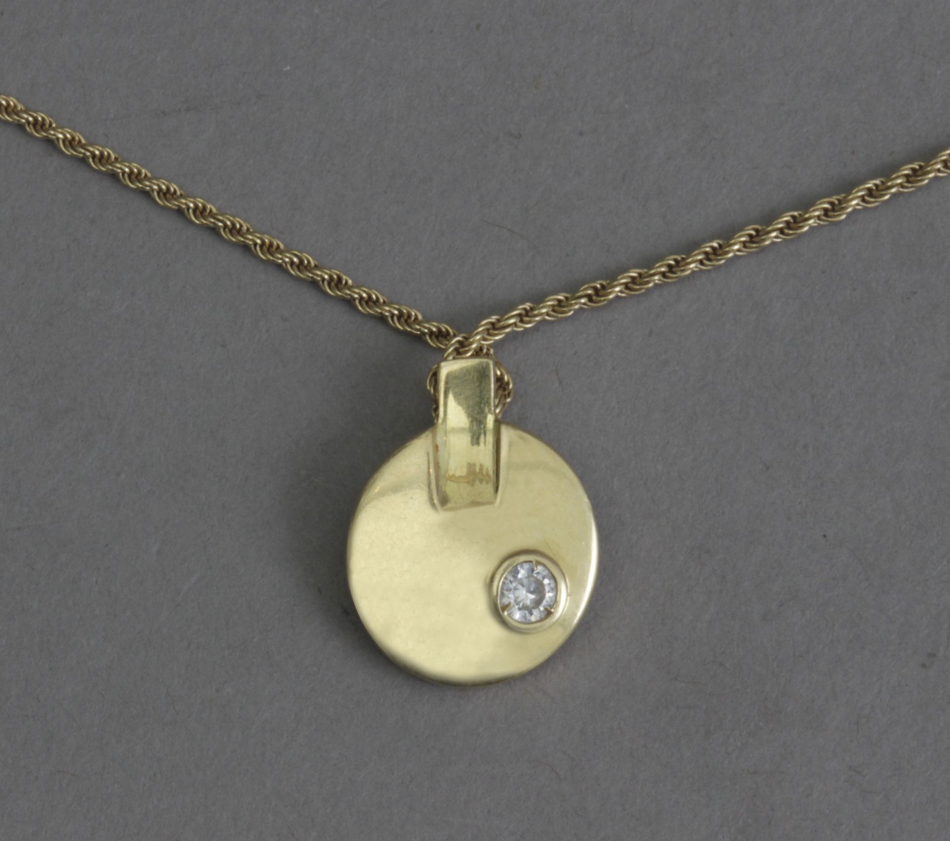 A diamond and gold pendant and chain