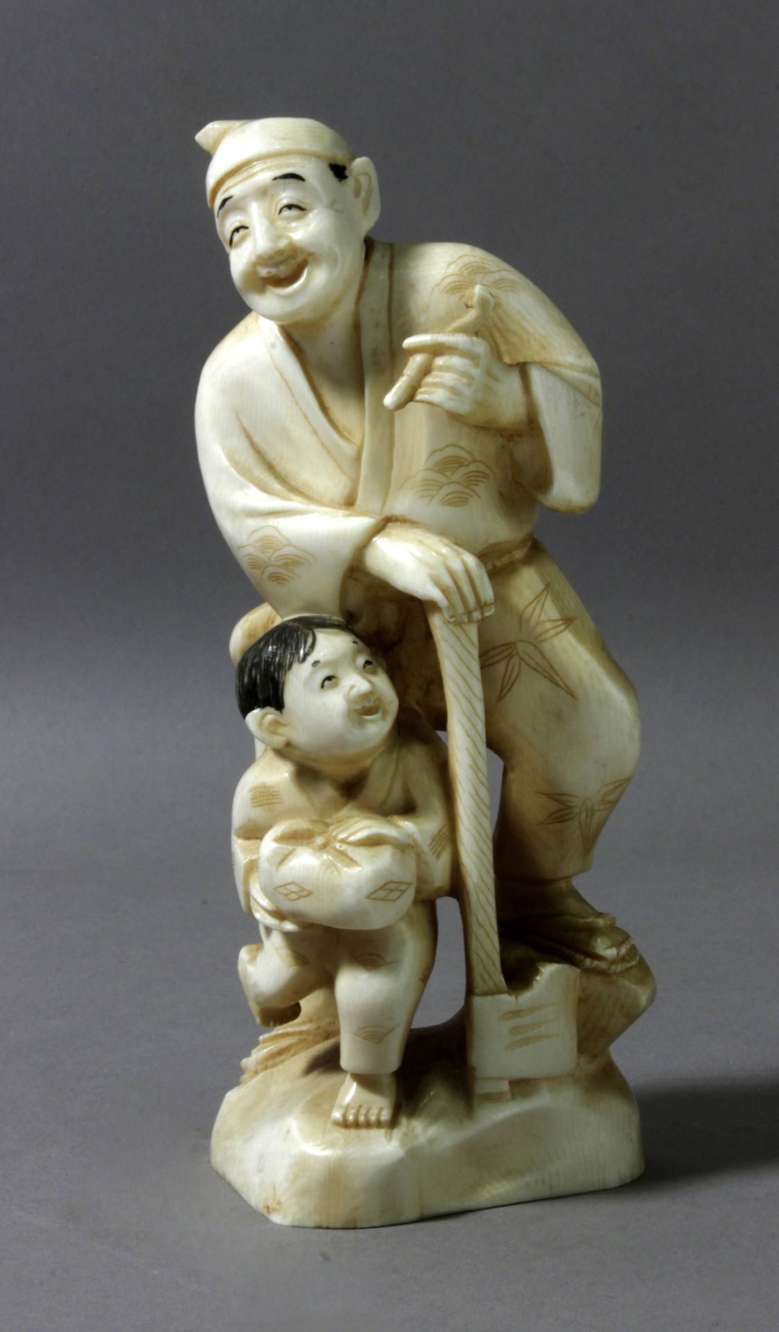 A 19th century Chinese ivory sculpture of a child and a lumberjack