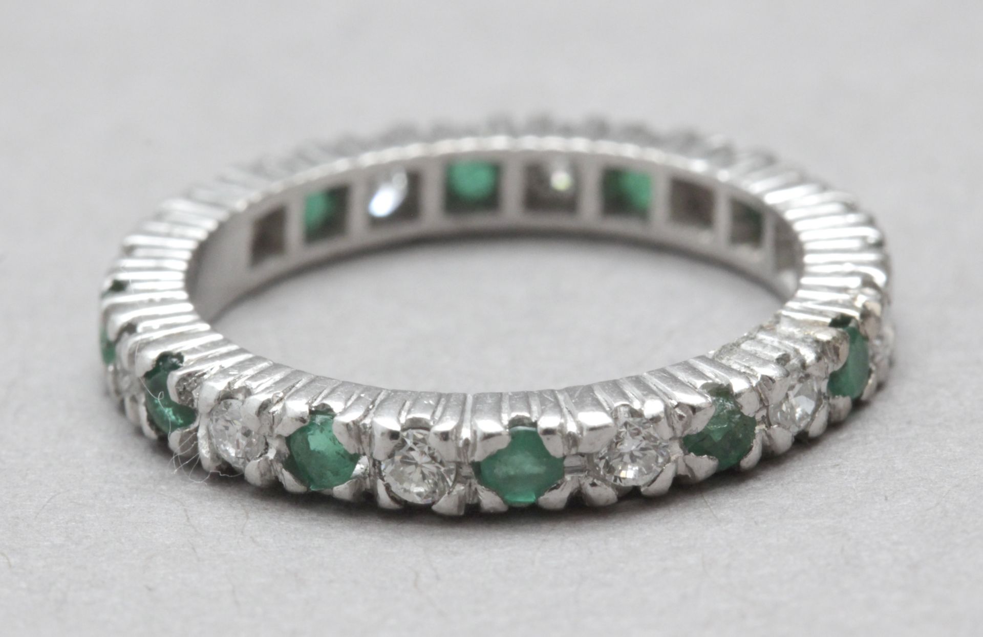 A brilliant cut diamonds and emeralds eternity ring