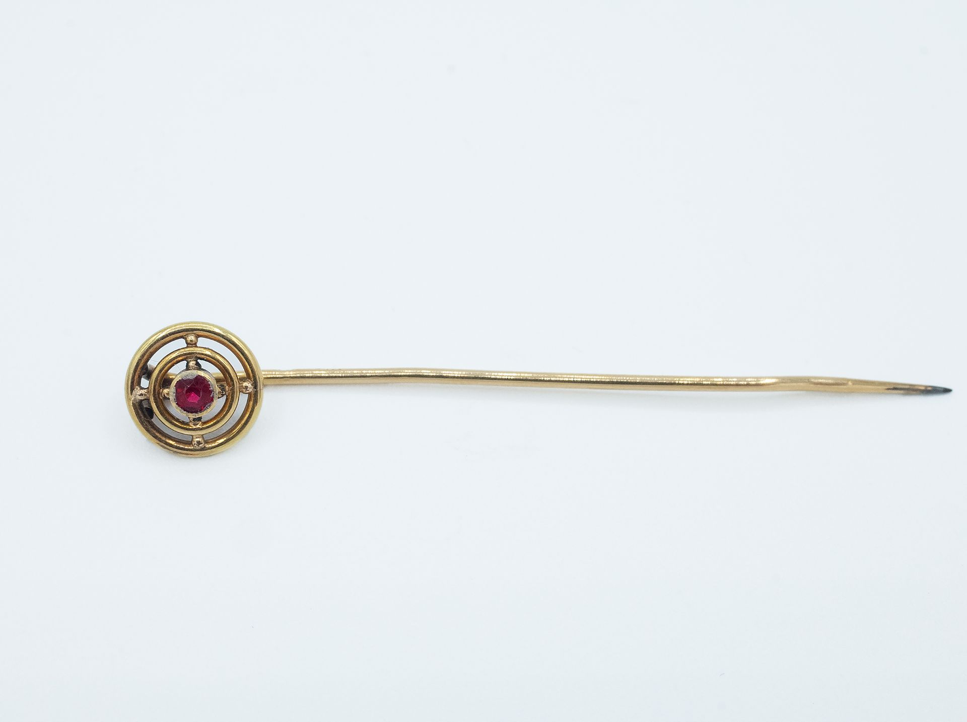 A mid 20th century gold and garnet tie pin