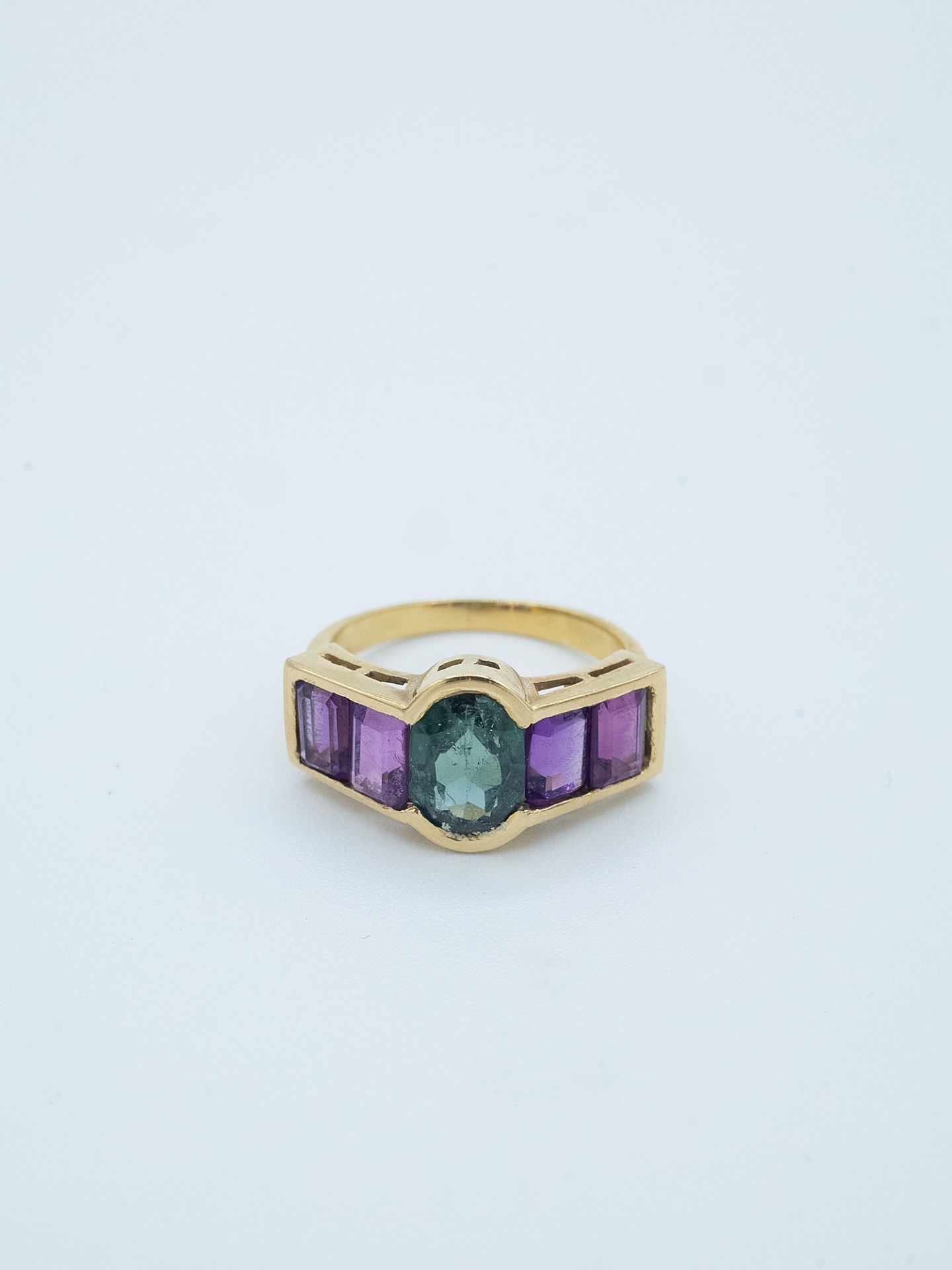 An 18k. yellow gold ring with a verdelite and amethysts