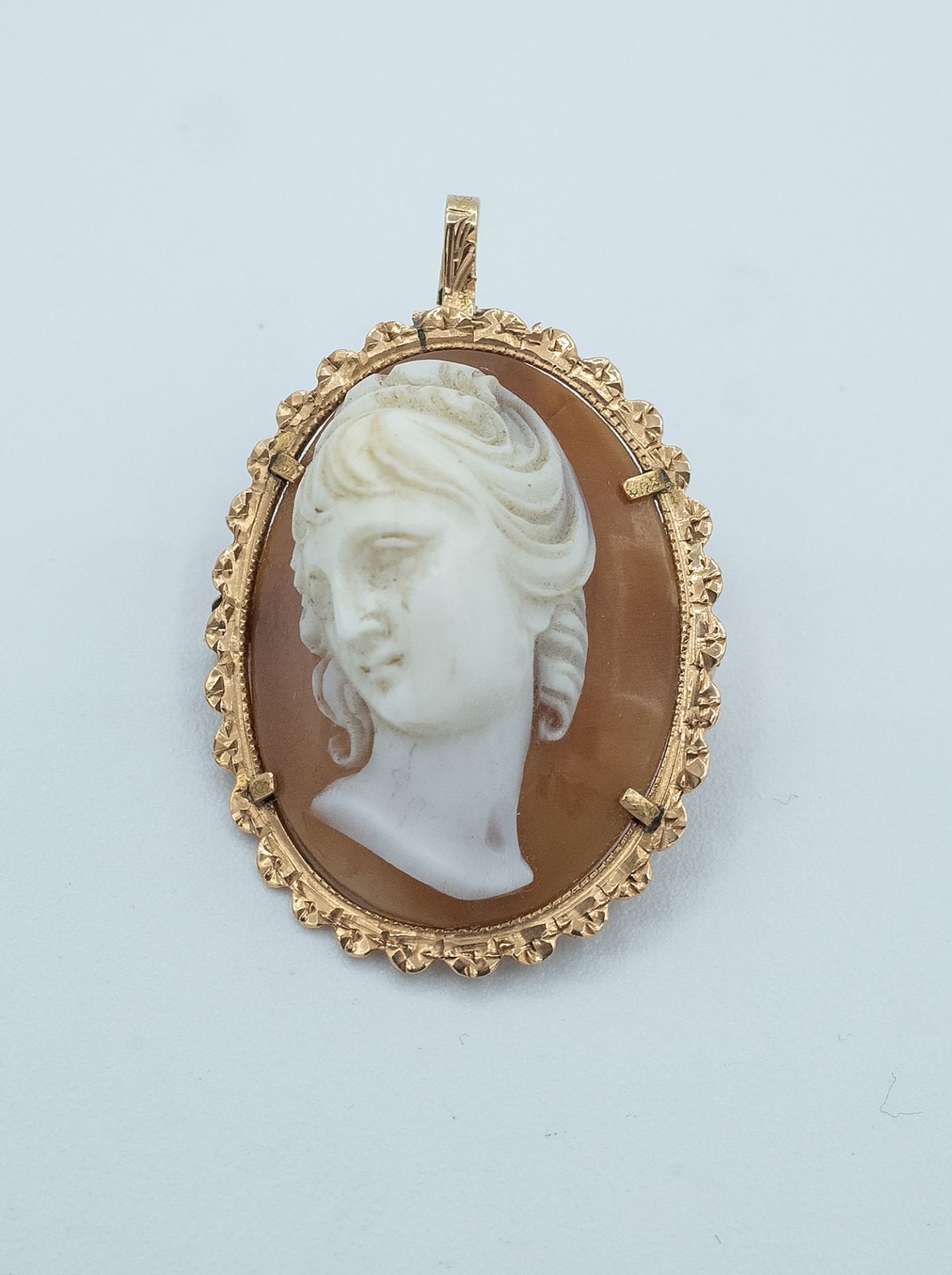 A second half of 20th century cameo pendant brooch with an 18 k. yellow gold setting