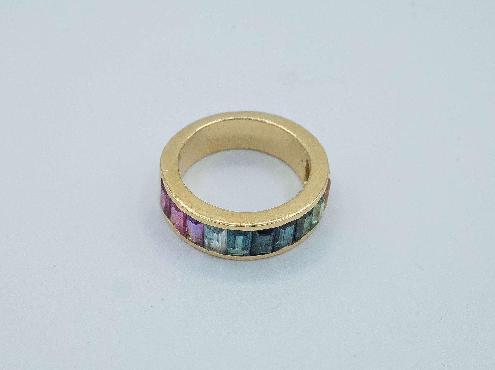A rainbow half eternity ring with coloured stones