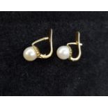 A pair of pearl earrings with an 18k. yellow gold setting