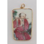 A Chinese gold pendant with a Kangxi porcelain plaque