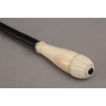 A 19th century walking stick with a carved ivory handle and an ebony shaft