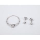 A set of diamond earrings and a solitaire ring