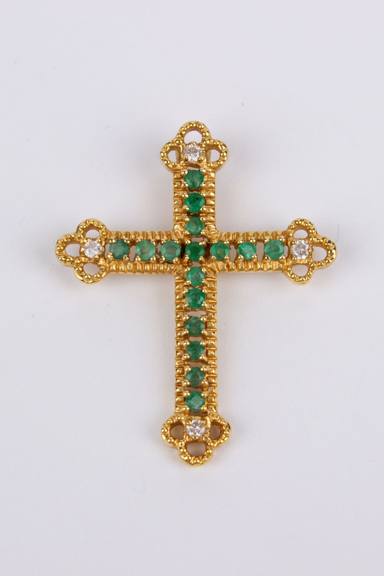 An 18k. yellow gold, brilliant cut diamonds and emeralds pendant cross