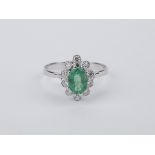 An emerald and brilliant cut diamonds 18k. white gold cluster ring