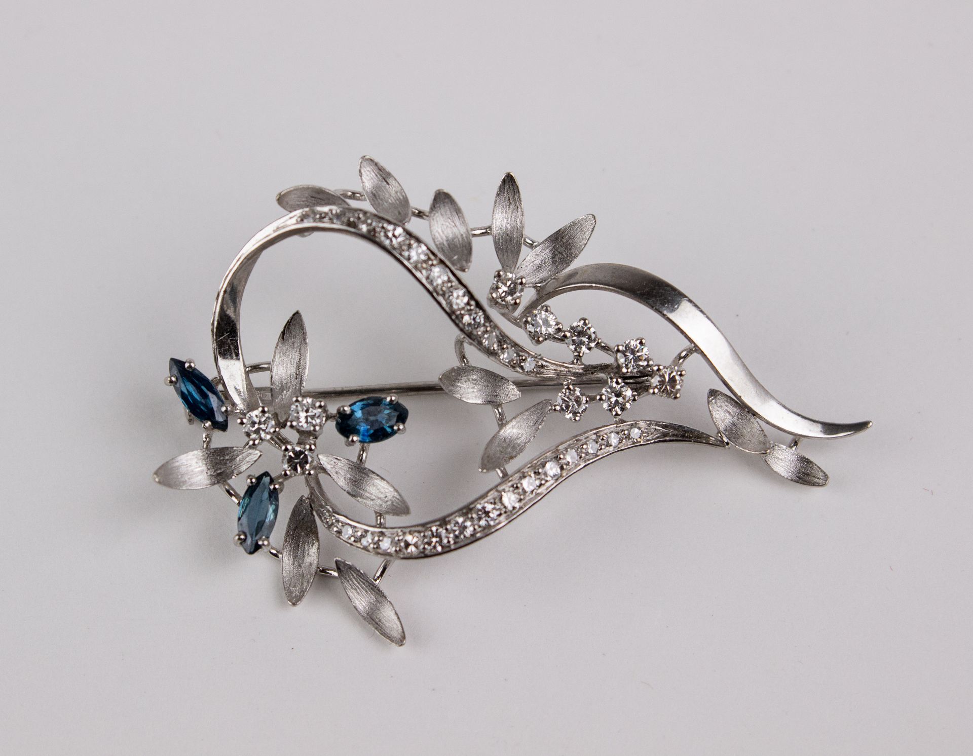 An 18k. white gold, sapphires and diamonds pendant brooch