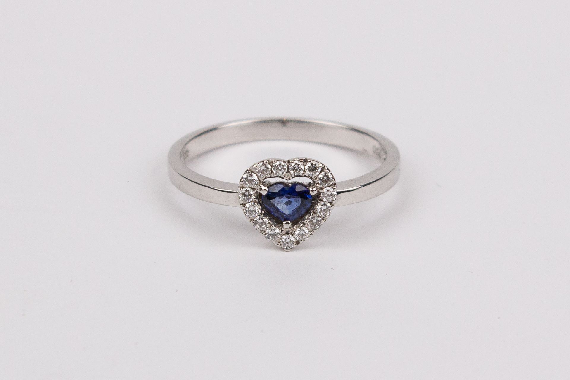 A sapphire and brilliant cut diamonds heart shaped ring