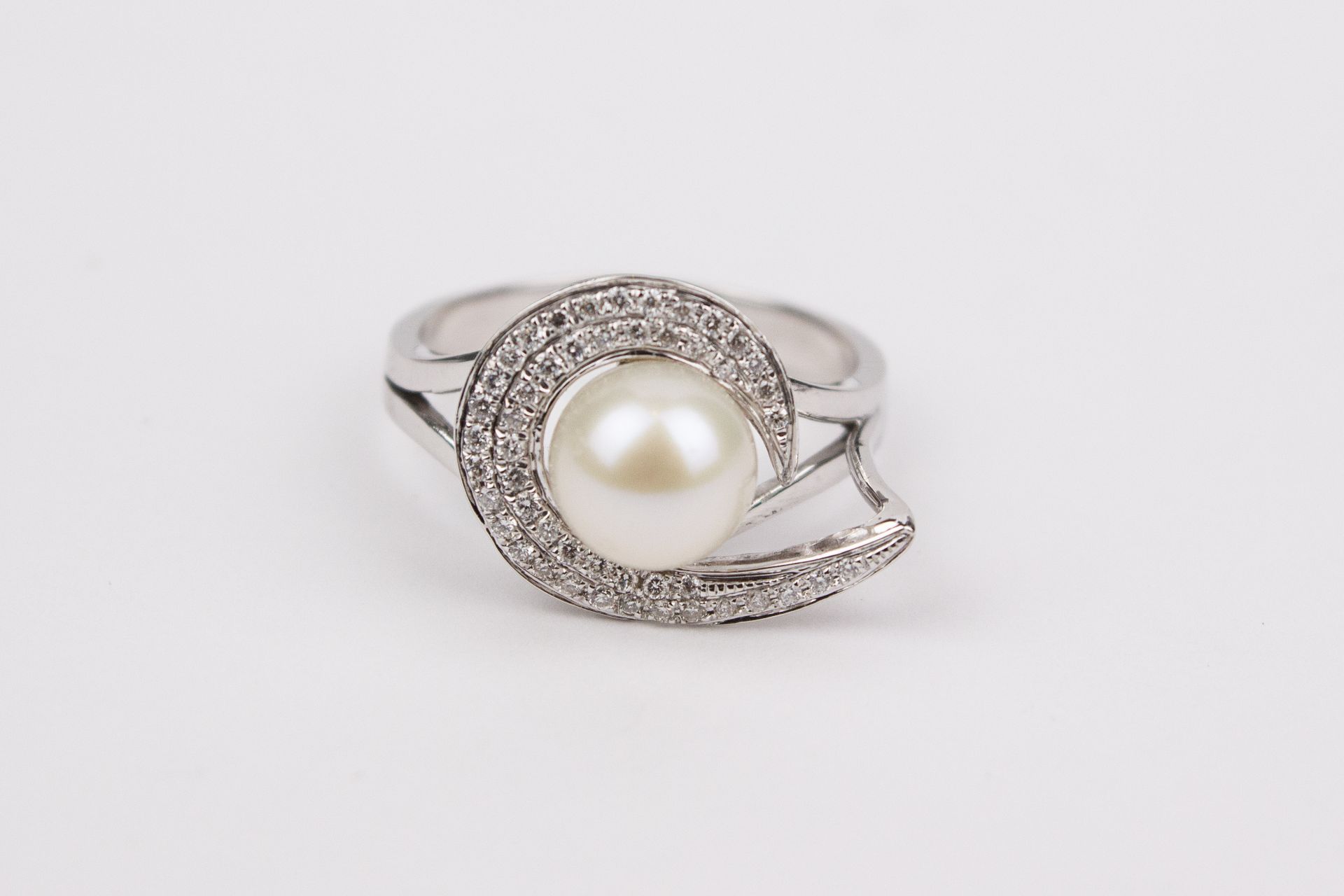A brilliant cut diamonds and a cultured pearl 18k. white gold cluster ring