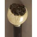 A 19th century Oriental walking stick with a carved ivory handle and a bamboo shaft