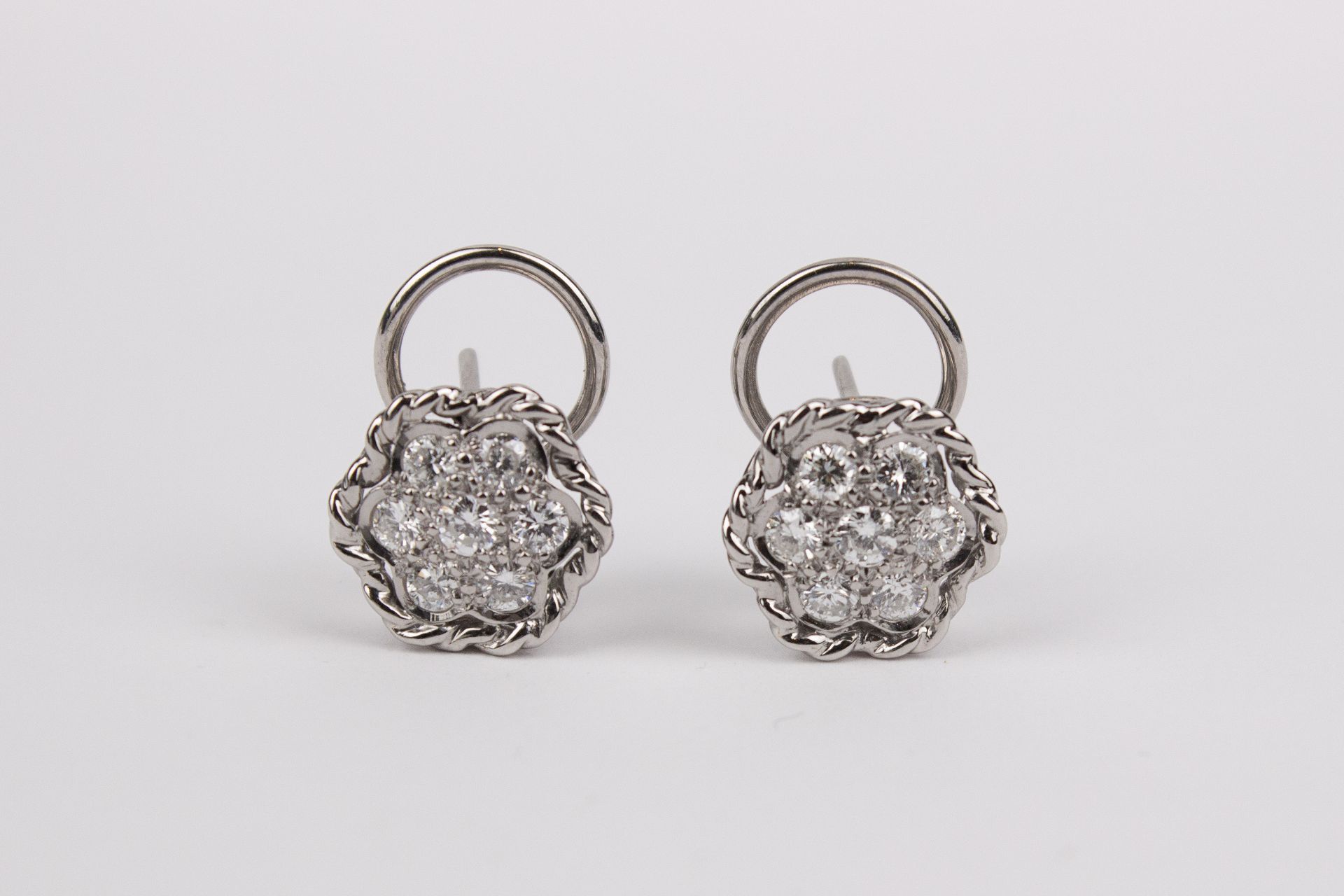 A pair of brilliant cut diamonds and 18k. white gold cluster earrings
