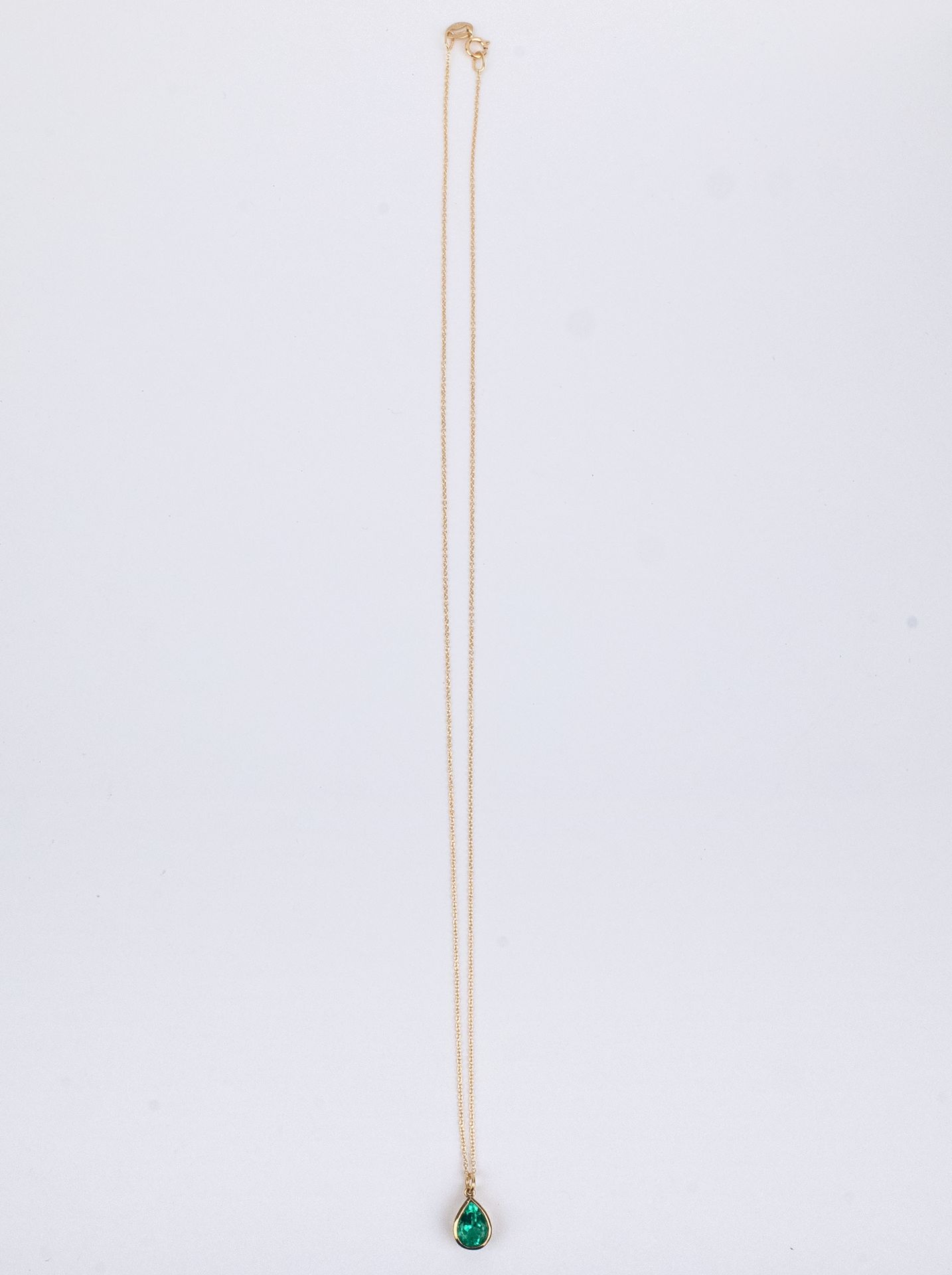 An 18k. yellow gold and emerald pendant and chain