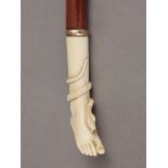 An early 20th century walking stick with a carved ivory handle and a cherry tree shaft