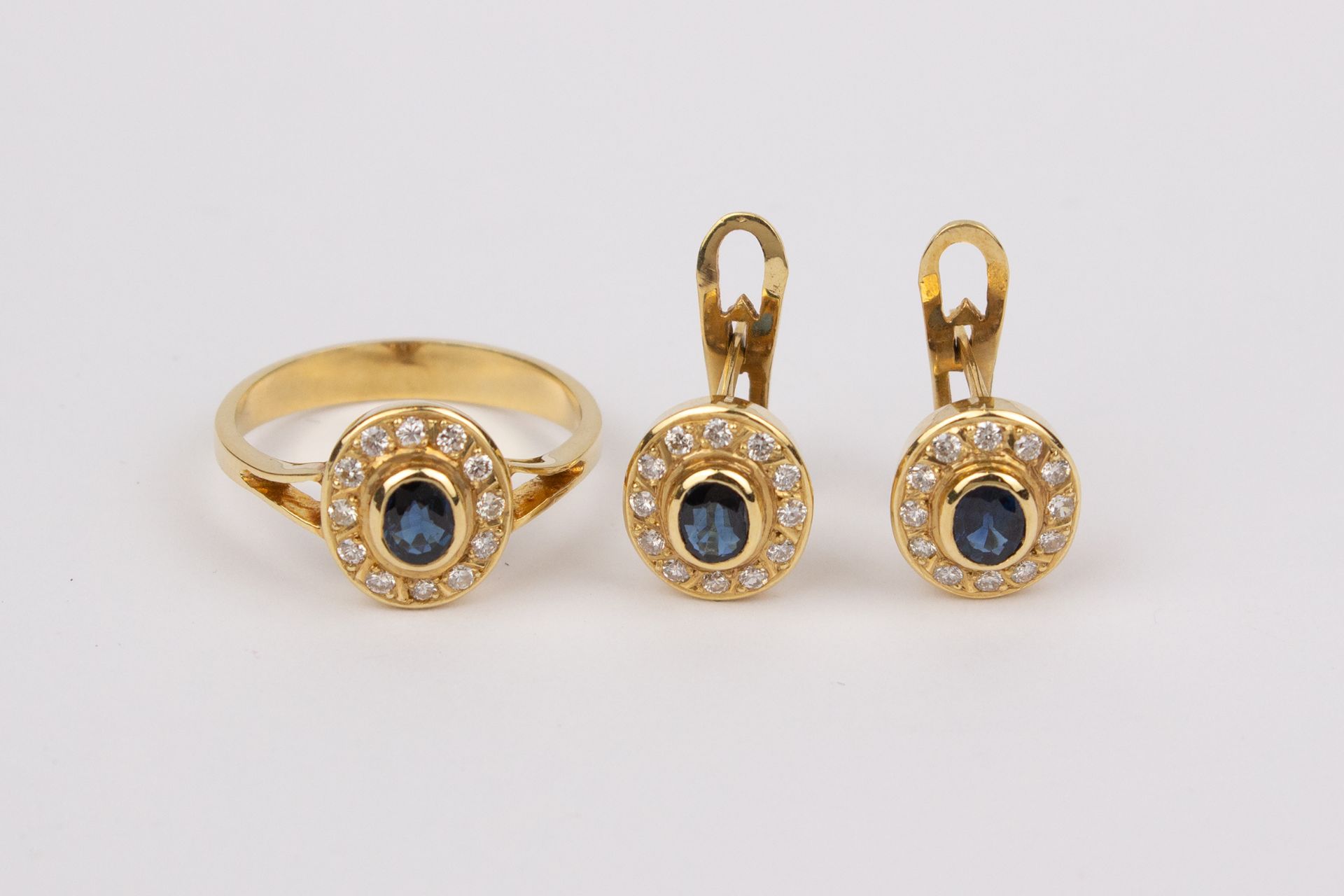 A set of 18k. yellow gold, sapphires and diamonds cluster ring and earrings