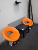 Two orange leather effect chairs, small side table
