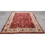 A large deep pile red / burgundy ground Oriental Carpet with multi borders and all over