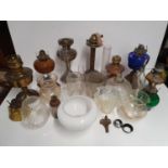 A quantity of Oil Lamps and various glass shades.