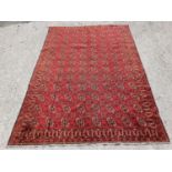 A vintage red ground Kerman Carpet with all over Bokhara design.