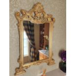 A Timber Gilt Overmantel Mirror with a highly decorative outline. 91 x 130 cms.