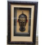 An Unusual Brass and Copper African head in relief. Framed.