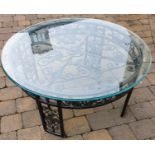 A metal circular Table with glass top.