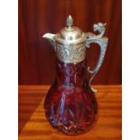 A very heavy Cranberry Glass Claret Jug with a highly embossed top and handle.