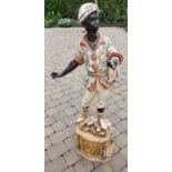 A large Italian Blackamoor Figure of a young Boy on a stand. 152 cms high approx.