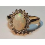 A 9ct gold opal and brilliant-cut diamond cluster ring. Estimated total diamond weight 0.20ct.