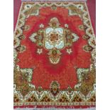 A modern red ground Rug with cream red and green border, central cream motif with green and cream