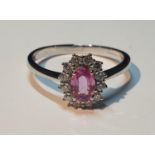 An 18ct gold pink sapphire and diamond cluster ring. Pink sapphire weight 0.53ct. Total diamond